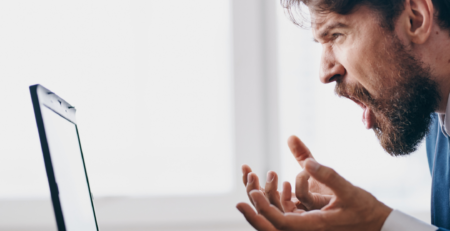 Profile of a businessman frustrated with what he's looking at on his computer screen.